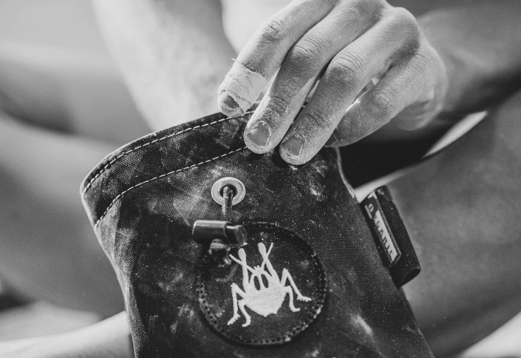 A hand reaching into a Grasshopper chalk bag