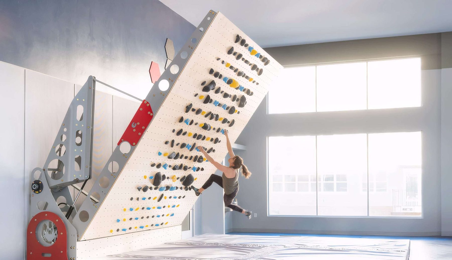 A Grasshopper adjustable climbing wall angled over a bright studio floor