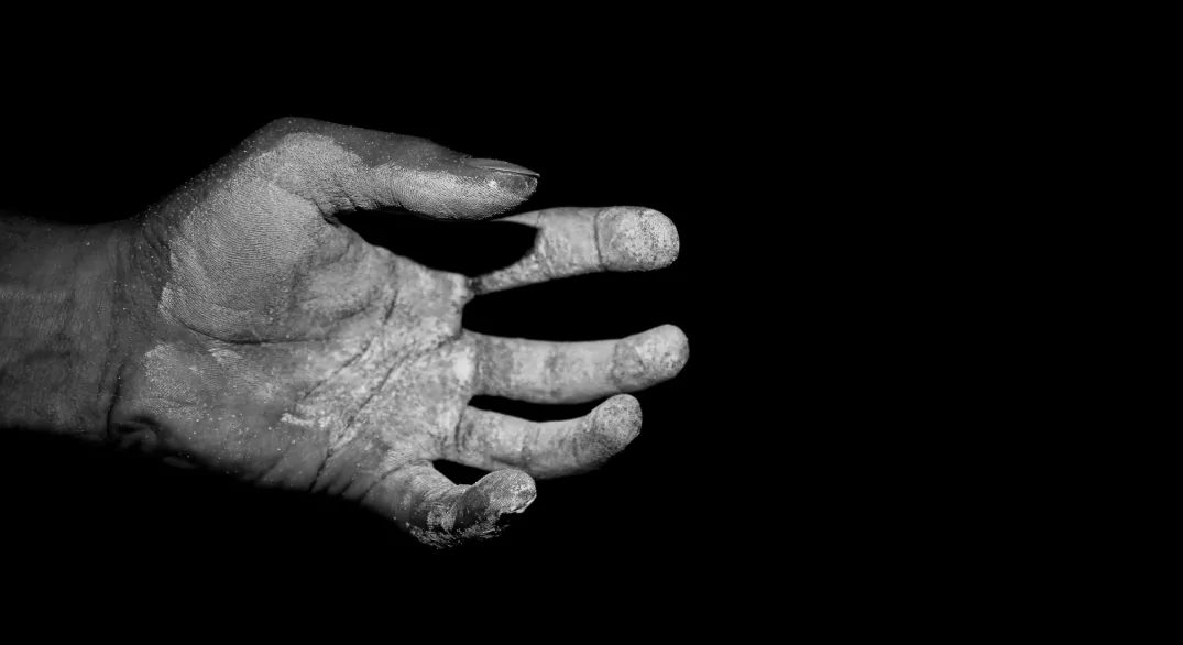 A chalked hand against black