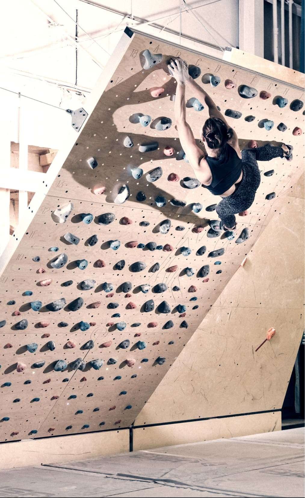 A climber working an overhang on a Grasshopper wall